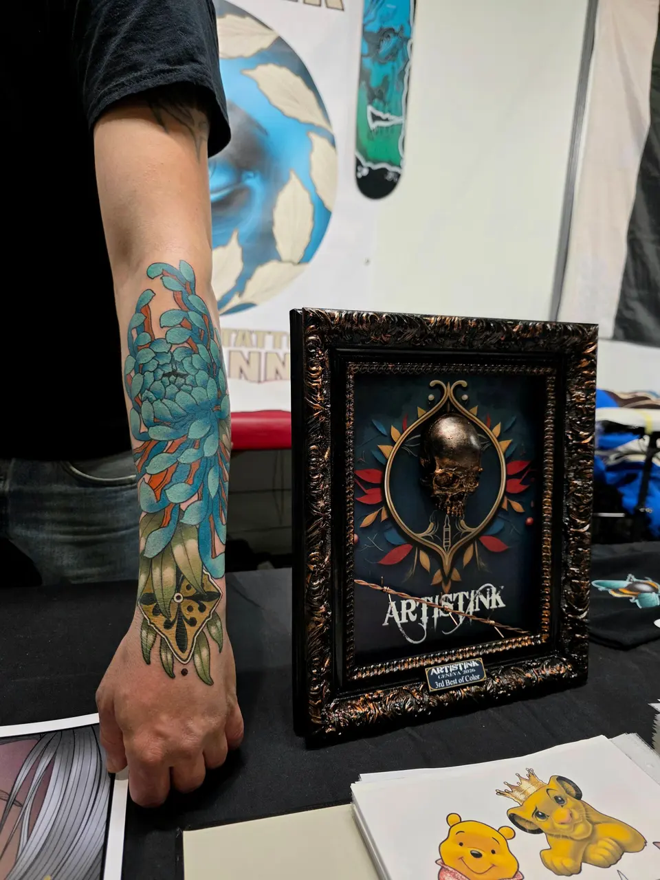 Avant-bras tatoué présenté à côté d'un trophée encadré