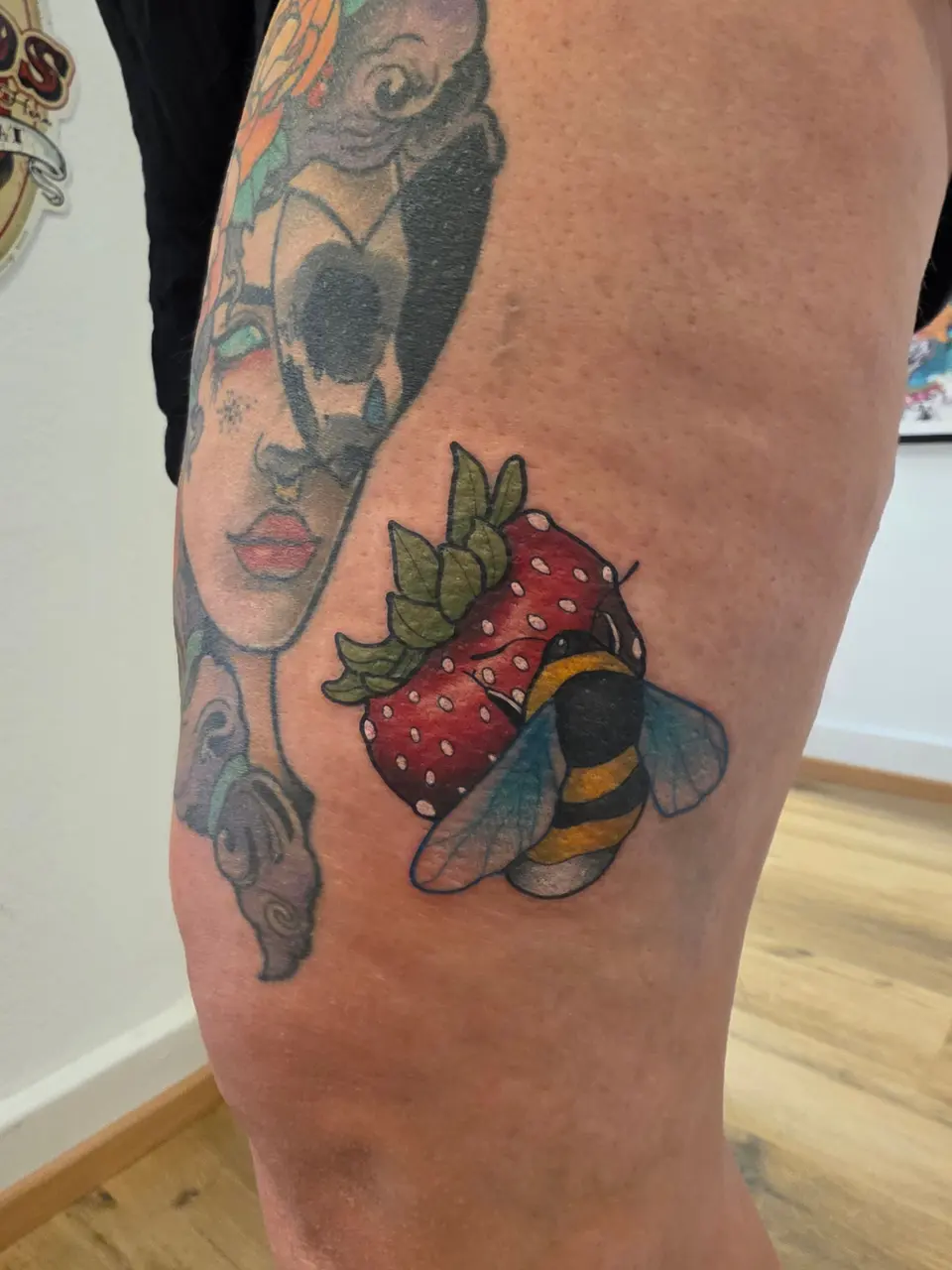 Fraise et abeille près d'un visage de femme, sur la cuisse