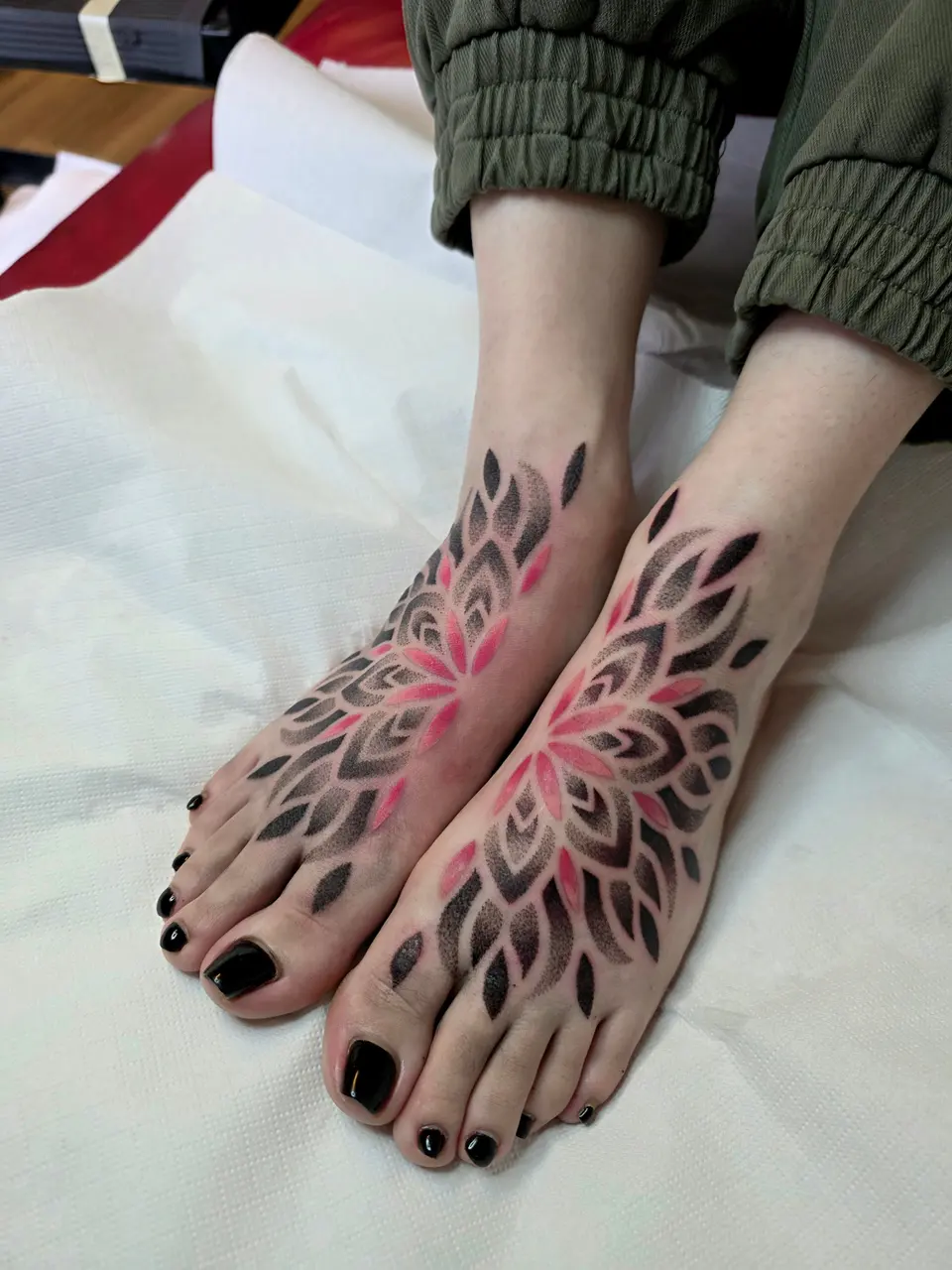 Deux mandalas symétriques noir et rouge sur le dessus des pieds