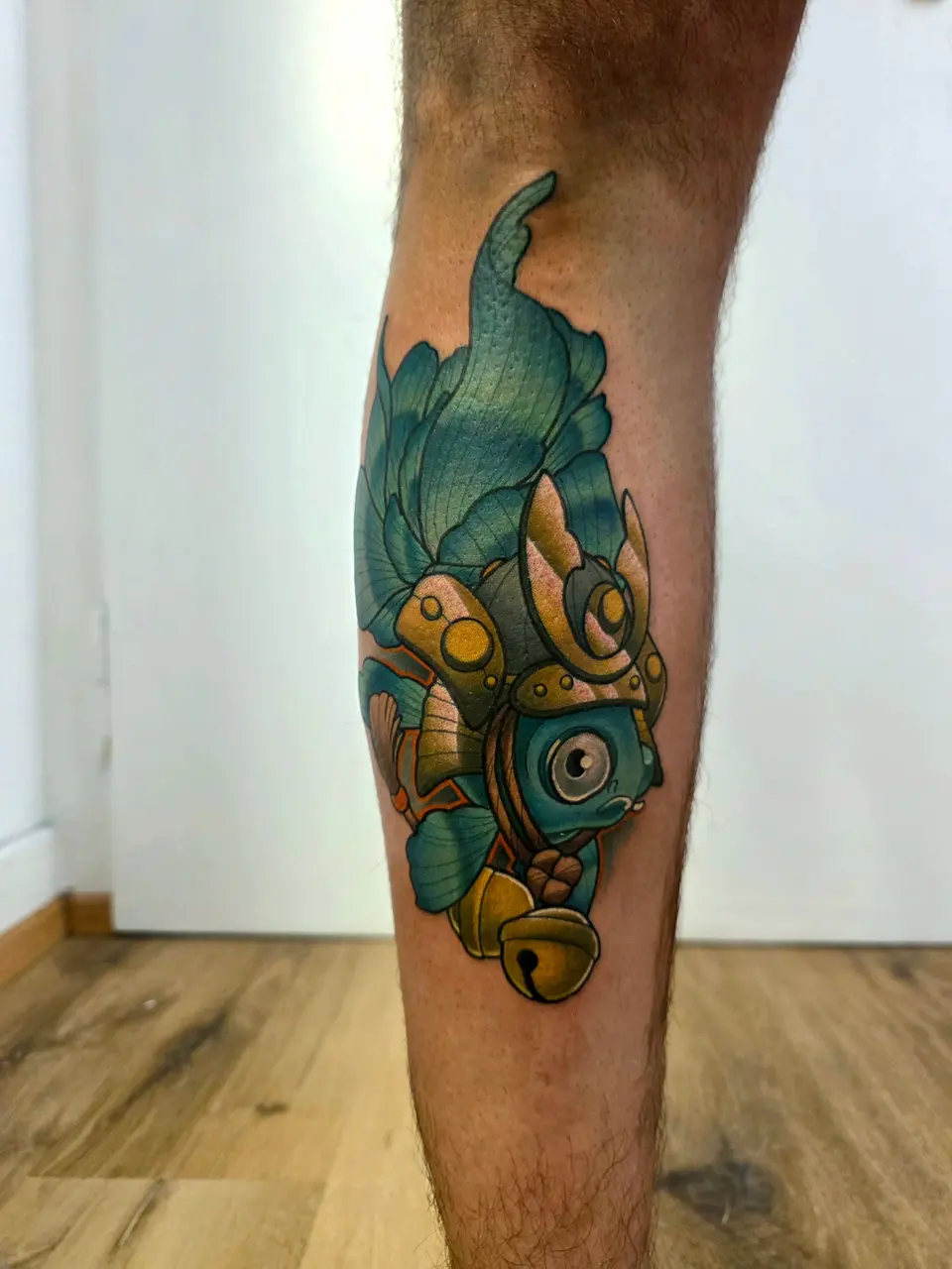 Poisson bleu canard au casque de samouraï tatoué sur un mollet